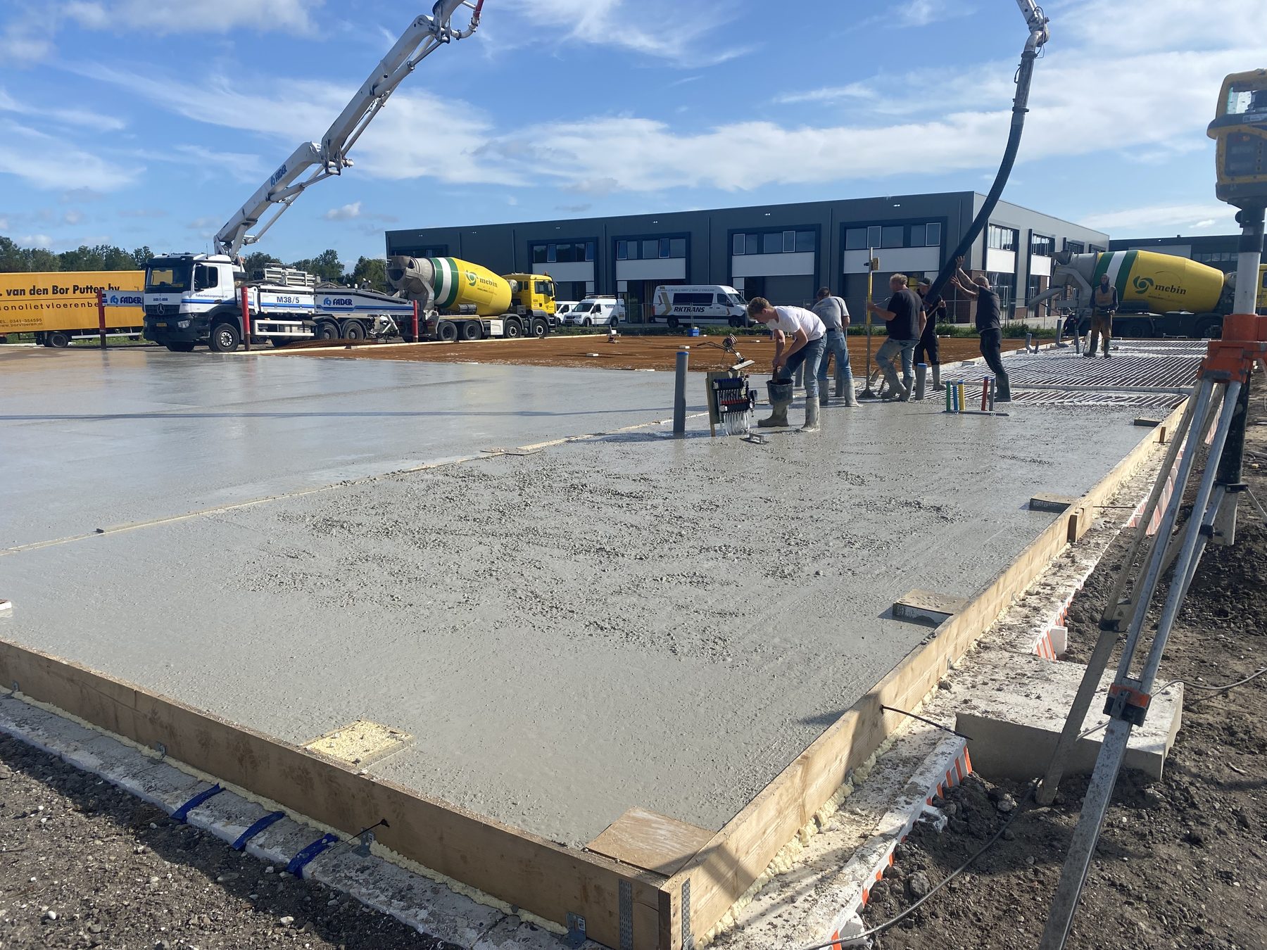 Betonpomp en vakmensen tijdens het storten