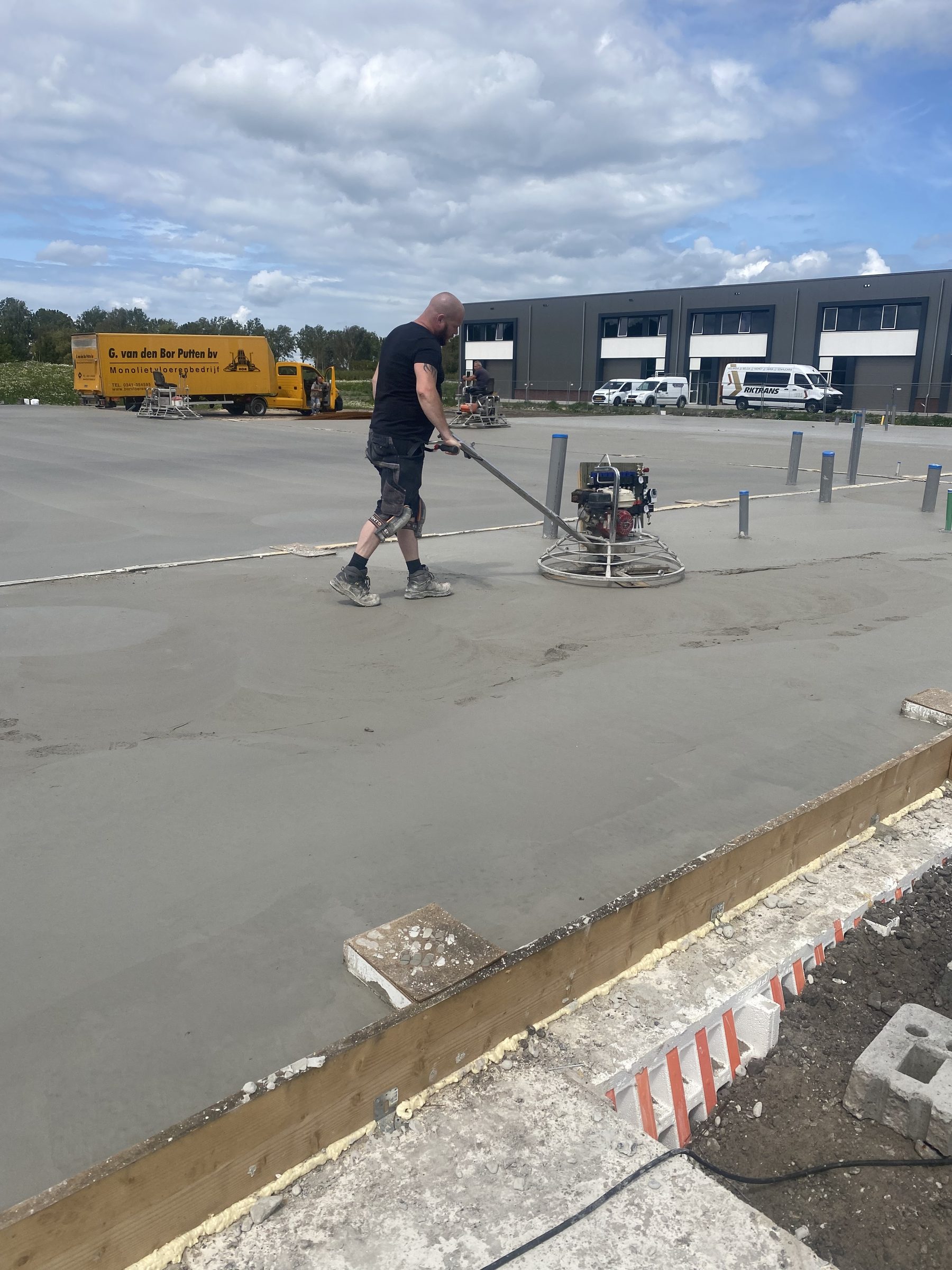 Vakman vlindert de betonvloer machinaal af